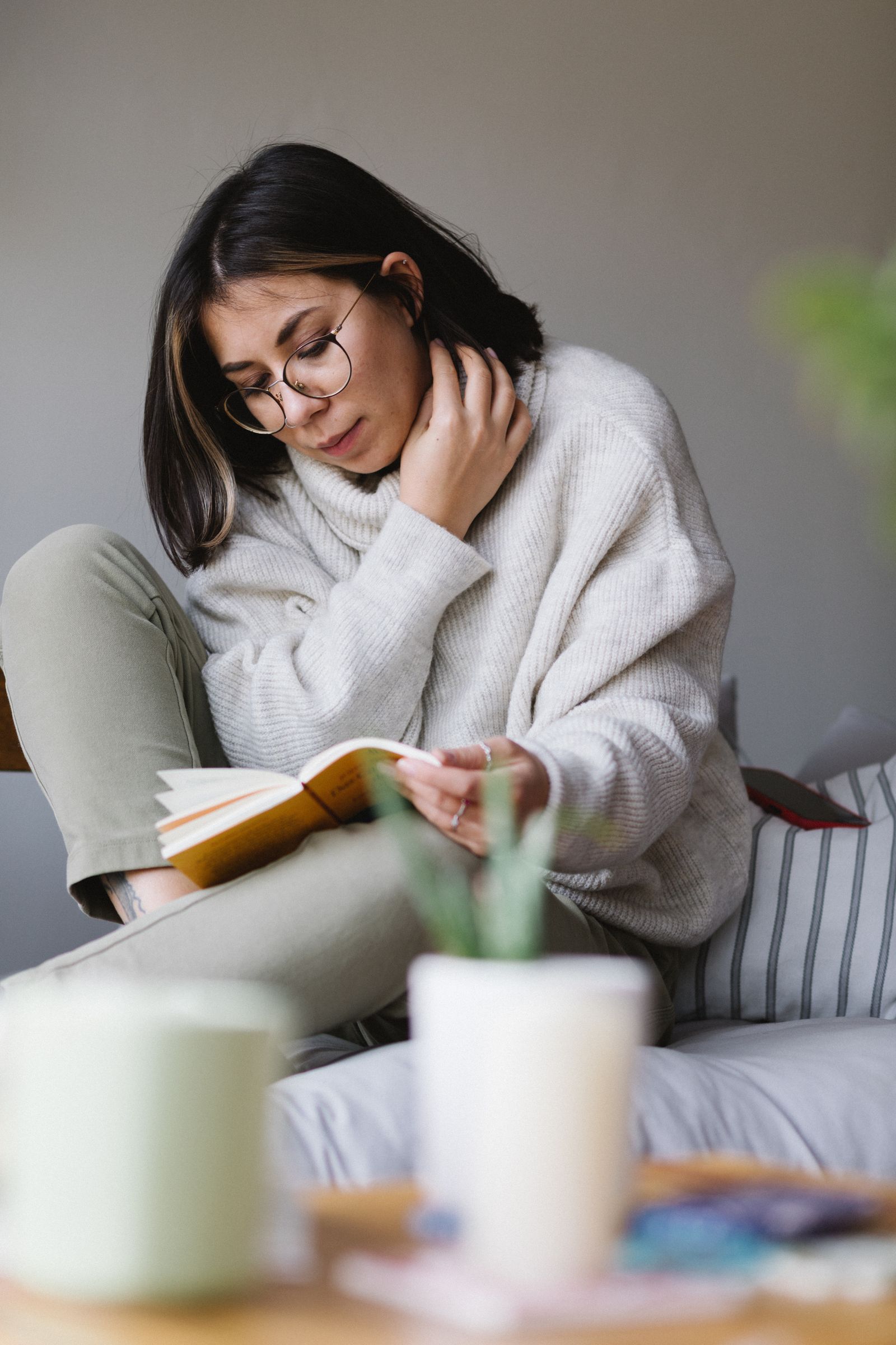 Woman reading a book on a couch at home