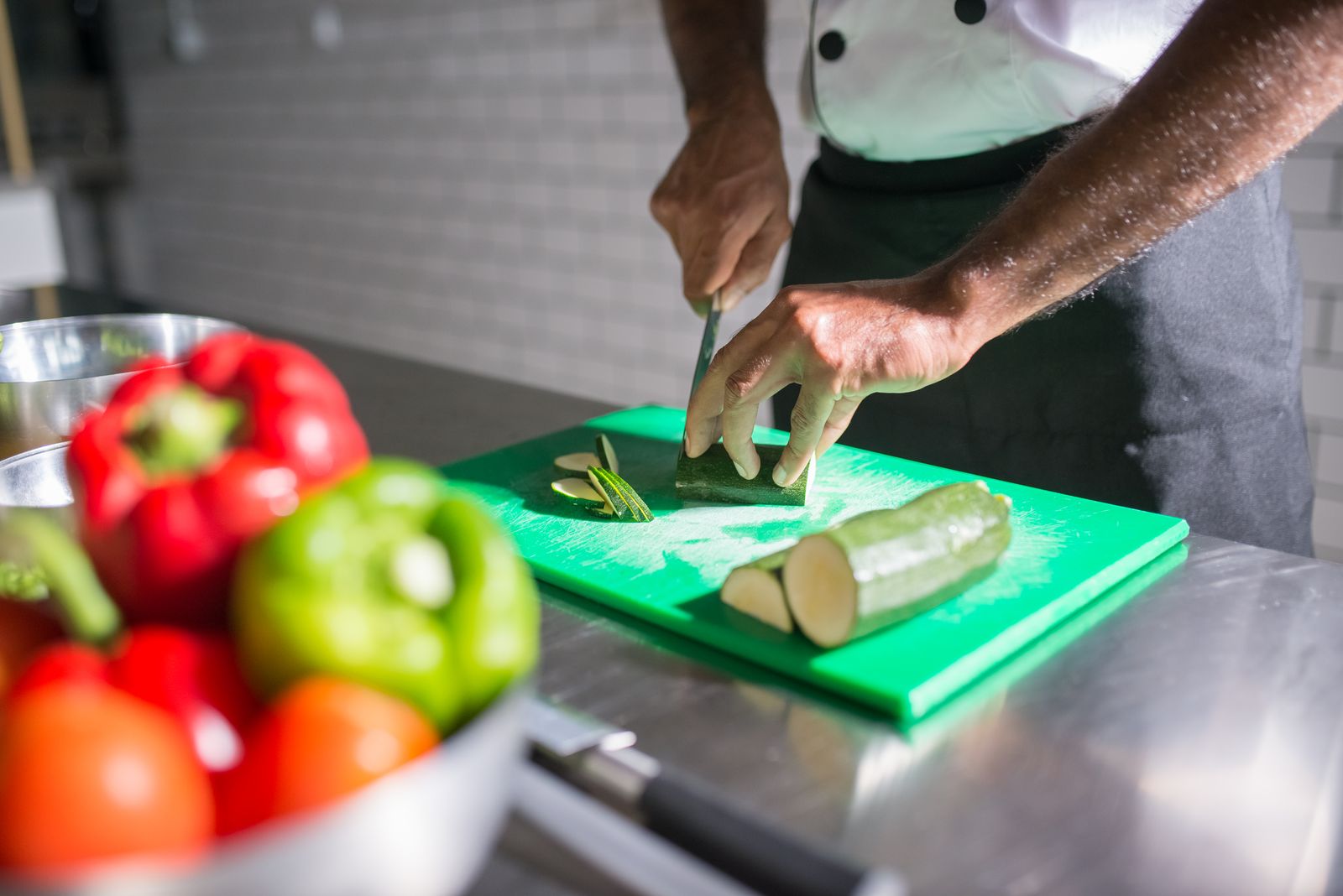 Person slicing a cucumber on a cutting board