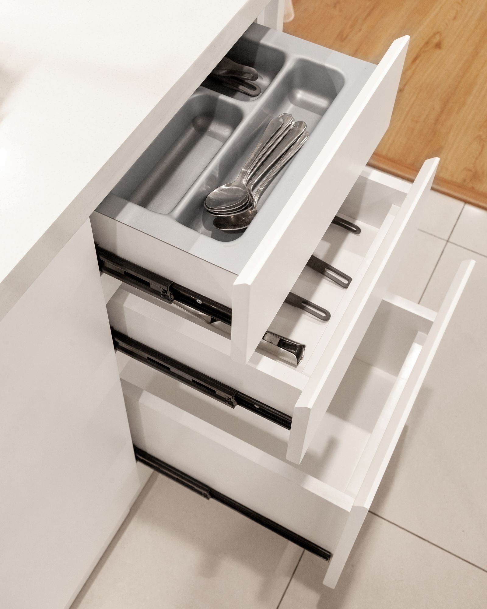 Gray utensil organizer inside a kitchen drawer