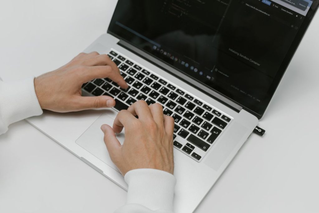 Hands typing on a laptop keyboard