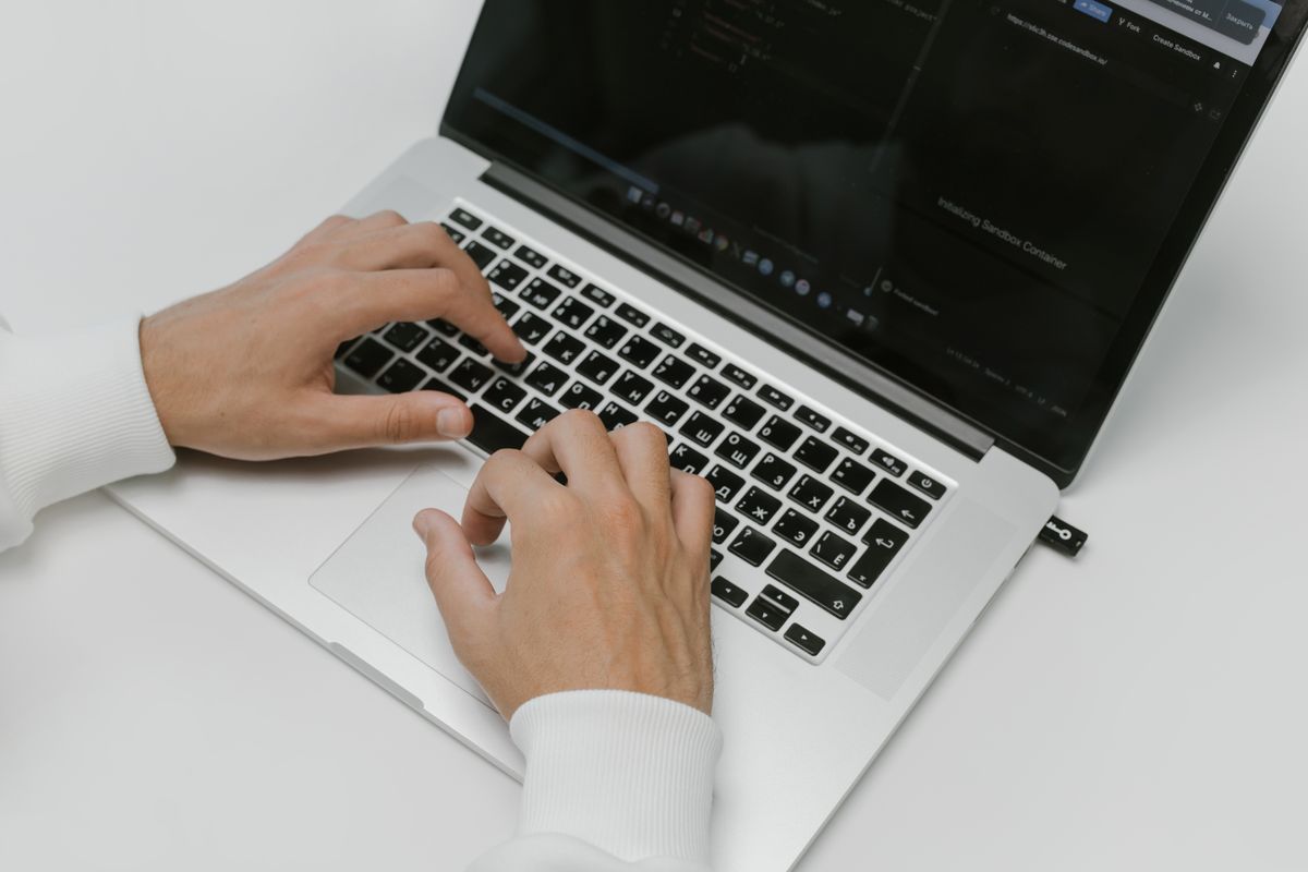 Hands typing on a laptop keyboard