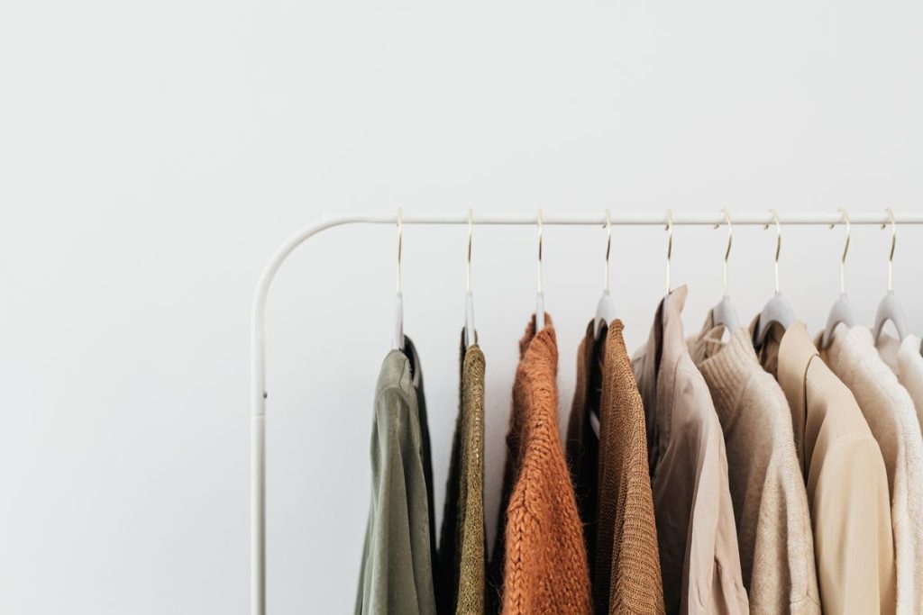 Sweaters and shirts hanging on a clothing rack