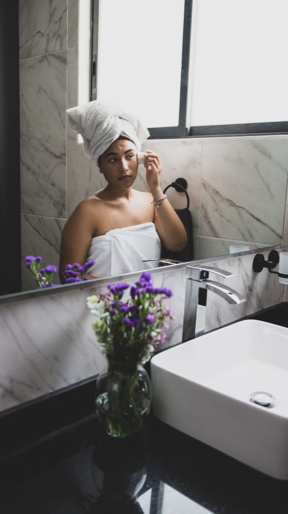 Woman at a bathroom mirror during her morning routine