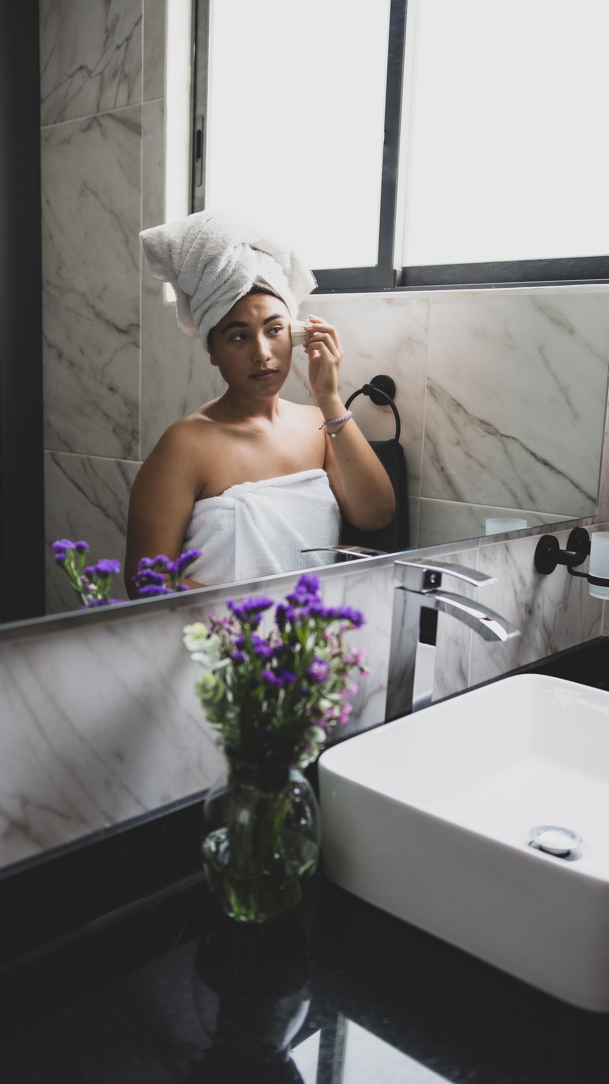 Woman at a bathroom mirror during her morning routine