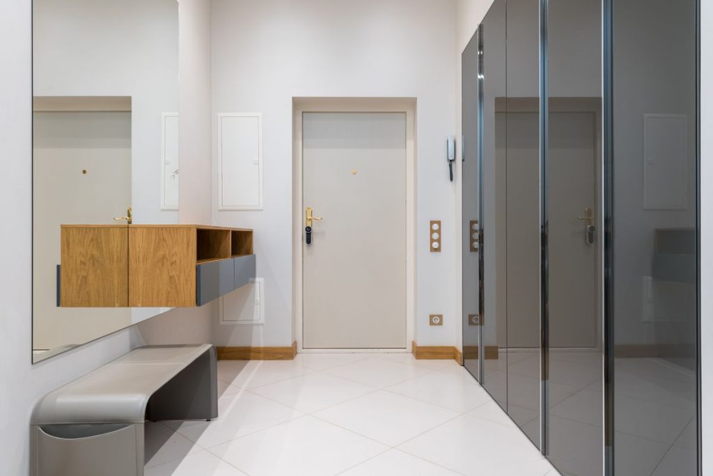 Bright, tidy entryway with a bench, mirror, and storage cabinets