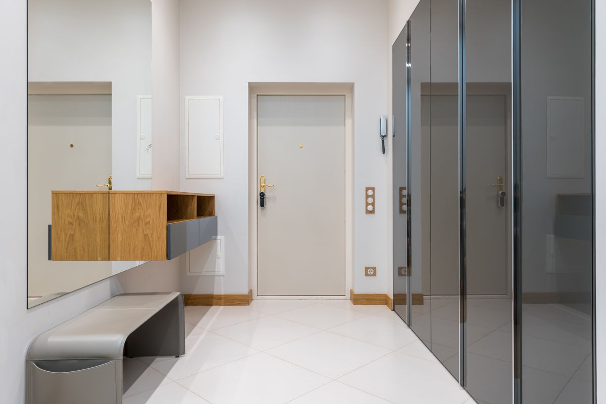 Bright, tidy entryway with a bench, mirror, and storage cabinets