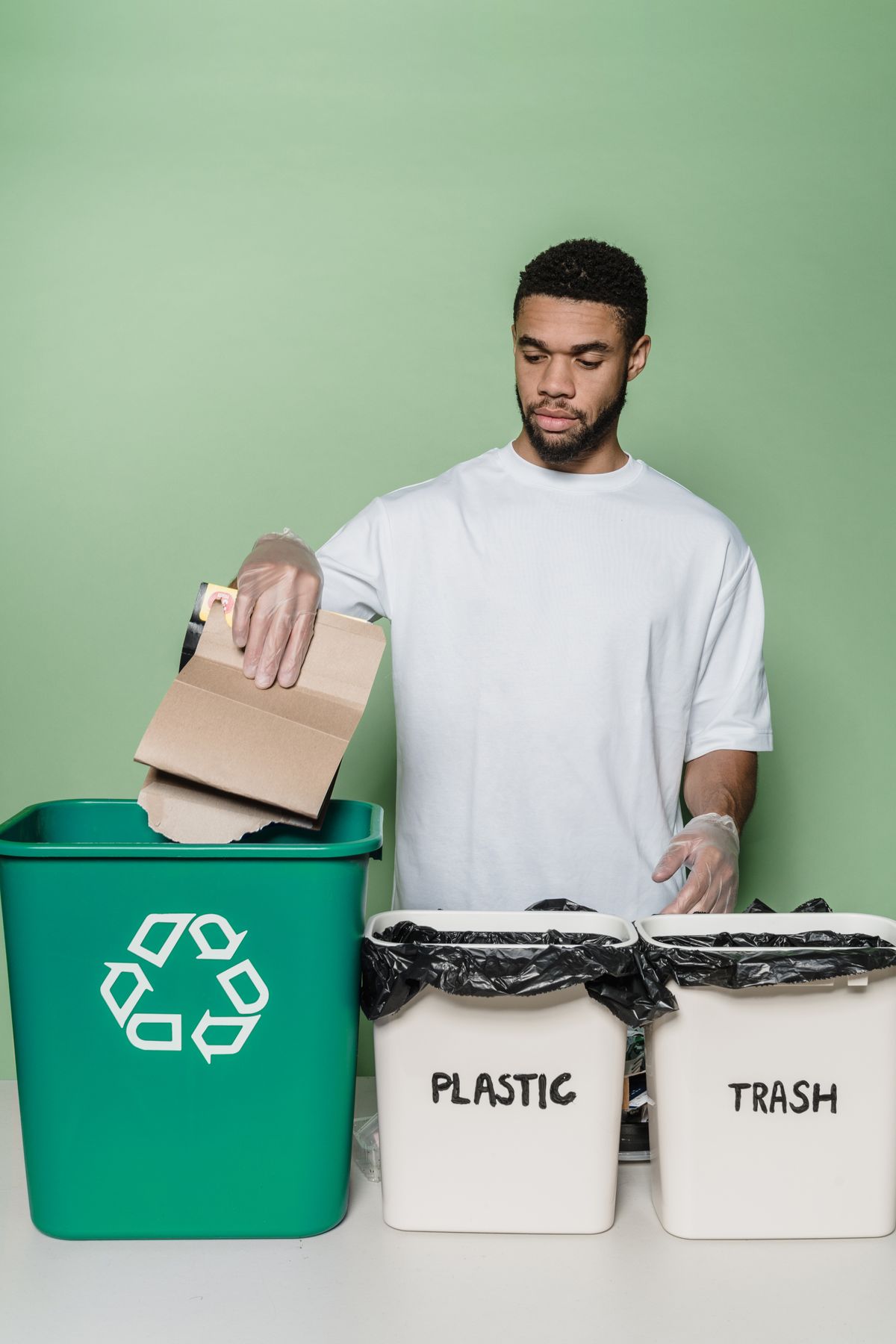 Man sorting cardboard into labeled recycling bins