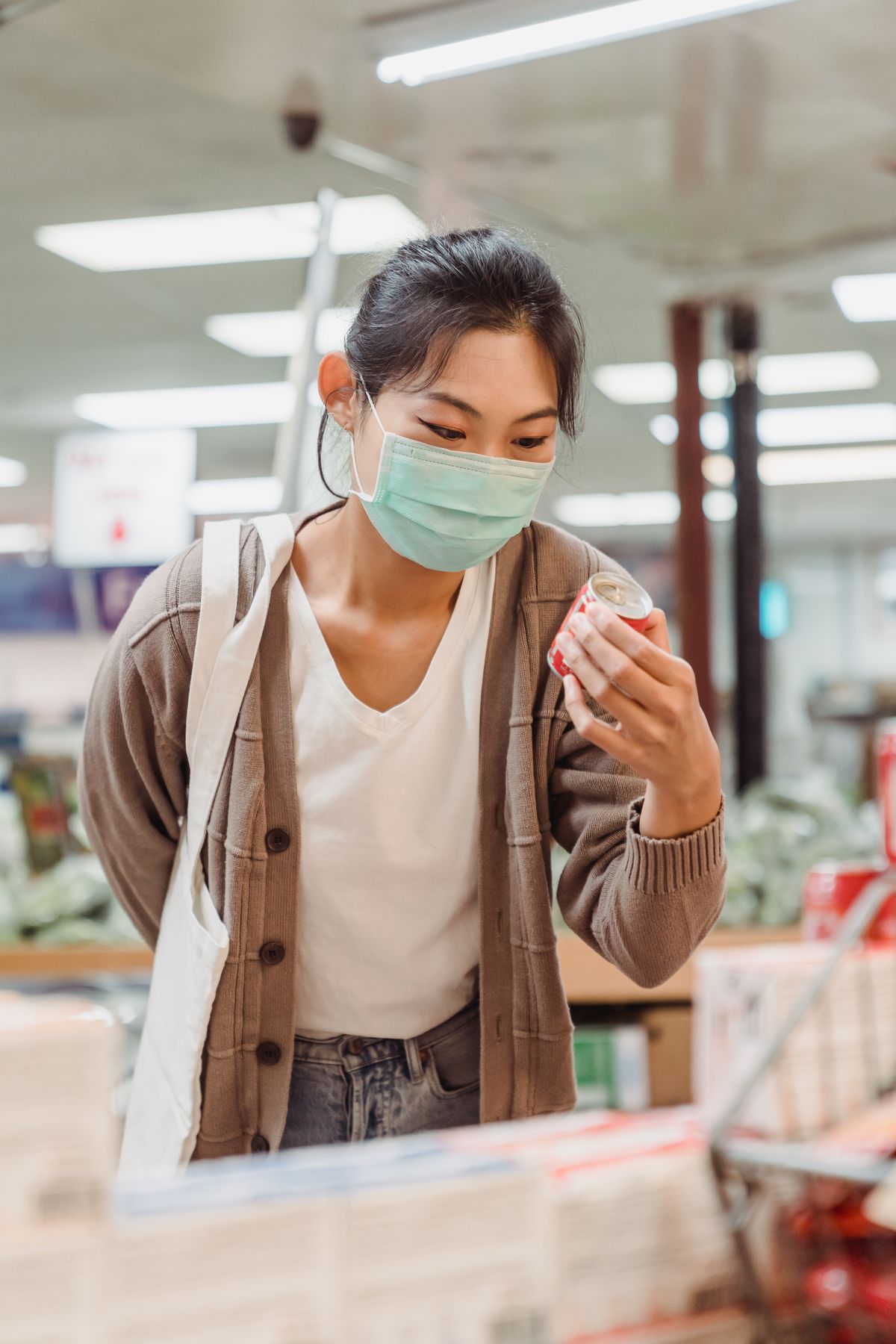 Woman reading a food label in a supermarket