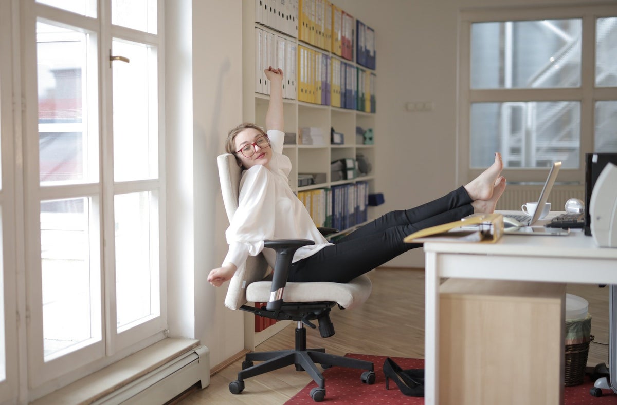 Woman stretching in her chair at an office desk